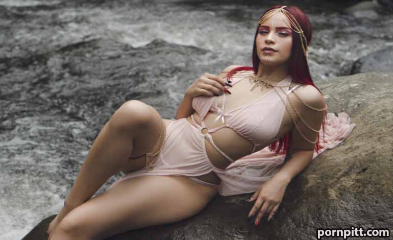 Modern dating Sexuality: The Honest Truth You Need Now Woman in pale pink lingerie lounging on a large rock beside flowing water, gazing at the camera with relaxed pose.